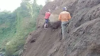 menurunkan batu besar di tebing pasir