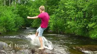 slowmotion   boy standing on stone in river   water splashing