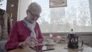 Senior woman in cafe websurfing on internet. An elderly man with a tab