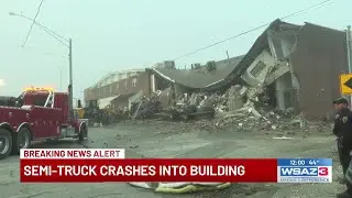 Semi-truck crashes into building