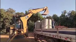 Descarregando tubos com retro escavadeira cat 416