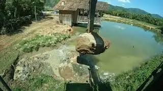 Escavadeira colocando pedras dentro de lagoa e fazendo nova MUMUU