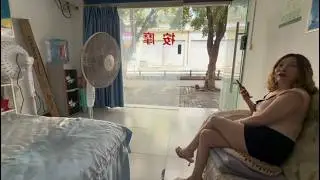 A quiet massage street in Xipeng Town, China, with green trees lining the streets