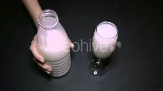 Woman Pouring Milk Into a Glass of Champagne