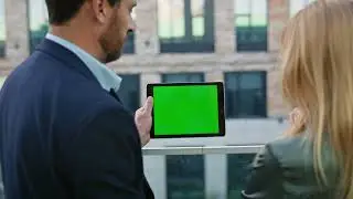 Two coworkers looking mockup tablet at urban district closeup. Business couple