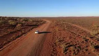 Drone following a white vehicle driving through the Australian Outback