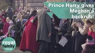 Prince Harry rubs Meghan's back affectionately as they greet crowds