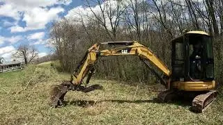 CAT 303 pulling out brush