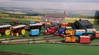 Bachmann Yellow Rheneas pulling 2 brown 3 grey slate wagons, blue box van and red brakvan 