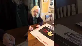Jill Gibson, signing her own photograph of Jimi Hendrix at Monterey Park Pop Festival