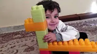 Small and funny kid (Emran )is making a simple blocks hours