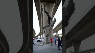 The men are standing, discussing what to do with the damaged bridge support after the earthquake