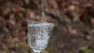 Water into glass jar. Slow motion. Stock footage.