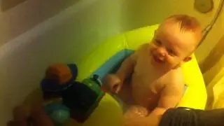 Baby laughing at bath toys