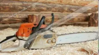Chainsaw builder at the site of construction of a wooden house. Many sawdust and a part of the