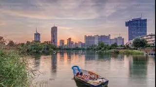 Sunset over Vienna international center skyscrapers with Kaiserwasser lake reflection view timelapse