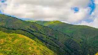 time lapse of clouds flying over green mountain slope at summer day in Kyrgyzstan