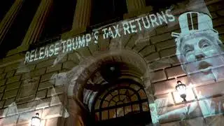 Trump related projections on IRS next to the Trump Hotel in Washington DC #TaxMarch