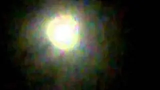 bright white moon with clouds  and light yellow orange glow around it  august 15, 2011