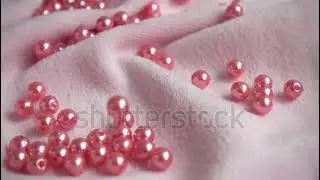 Pearls falling on the fabric. Slow motion.