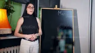 Young adult Caucasian female teacher or tutor stands ready to begin an online lesson in a modern