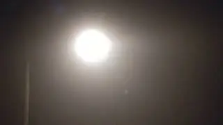 Street Light Shines Brightly Through The Fog At Night