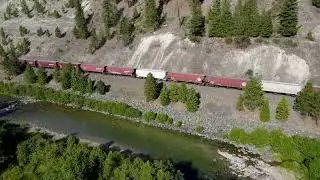4K Aerial Video of Train Moving Along a River.