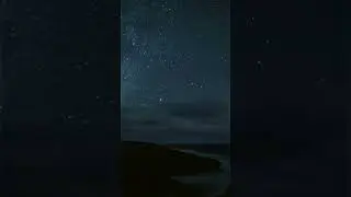 Timelapse: Shooting stars and the Atlantic Ocean transitioning to dawn over rocky shores.