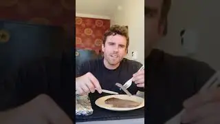 Guy cooks a steak with iron in hotel room