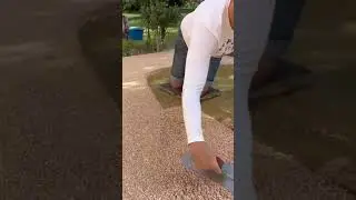 A man who is leveling a material in the yard of the house neatly