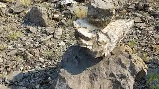 Rock piles on each side of desolate dirt road. Trail markers?