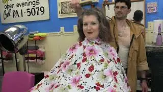 Hubby brushes Kat's hair while in a barber chair wearing shirt and tie