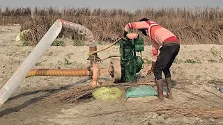 A farmer irrigating crops by extracting water from the ground using a water pump and diesel engine