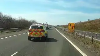 Police car straddles lane preventing motorist merging at road works