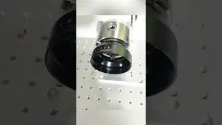 Laser marking machine precisely engraves camera lenses using a rotating axis