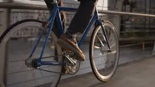 VideoVault Stock Video: Cyclist rides his bike over a bridge