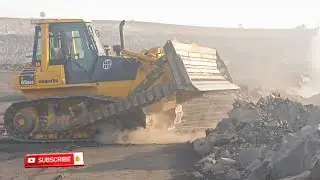 BIG EXCAVATOR MACHINE LOADING VOLVO DUMP TRUCK HARD ROCK AND KOMAT'SU DOZER DOZING MINING BARIAR