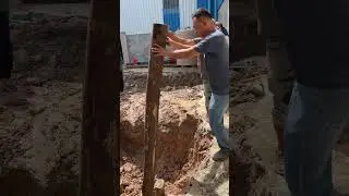 Excavator hits concrete with wooden poles,Excavator tractor digging pits