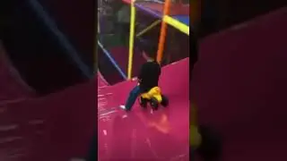 Kid rides down slide on bike