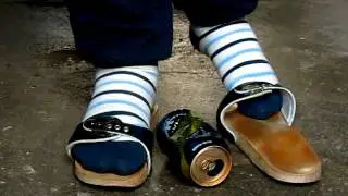 Blue exercise sandals with blue stripe socks flattening a blue beercan