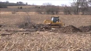 CAT 973C Crawler Loader pushing and stacking trees