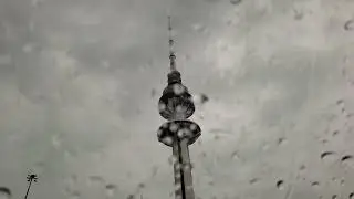 Heavy Rain drops on Car wind shield overlooking kuwait liberation tower, Driving in heavy rain