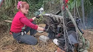 The girl repairs and restores the engine of a neighbor's car.