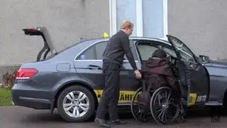 Pyörätuolia käyttävä asiakas taksissa