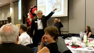 Ernie Rogers Benefit Auctioneer and Dave Henderson sell a signed football at a benefit auction.