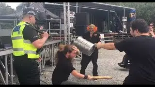 Funny fan hitting himself with a baseball bat during a Slipknot cover band performance