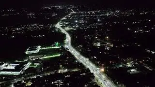 Aerial view of busy urban street with illuminated cars at night