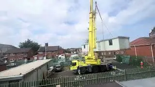 Crane truck moving a mobile office container