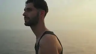 A Young Man Poses For Photos At The Beach