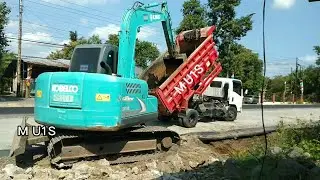 Excavator Kobelco SK75 Digging and Loading Dump Truck, Road Construction Work